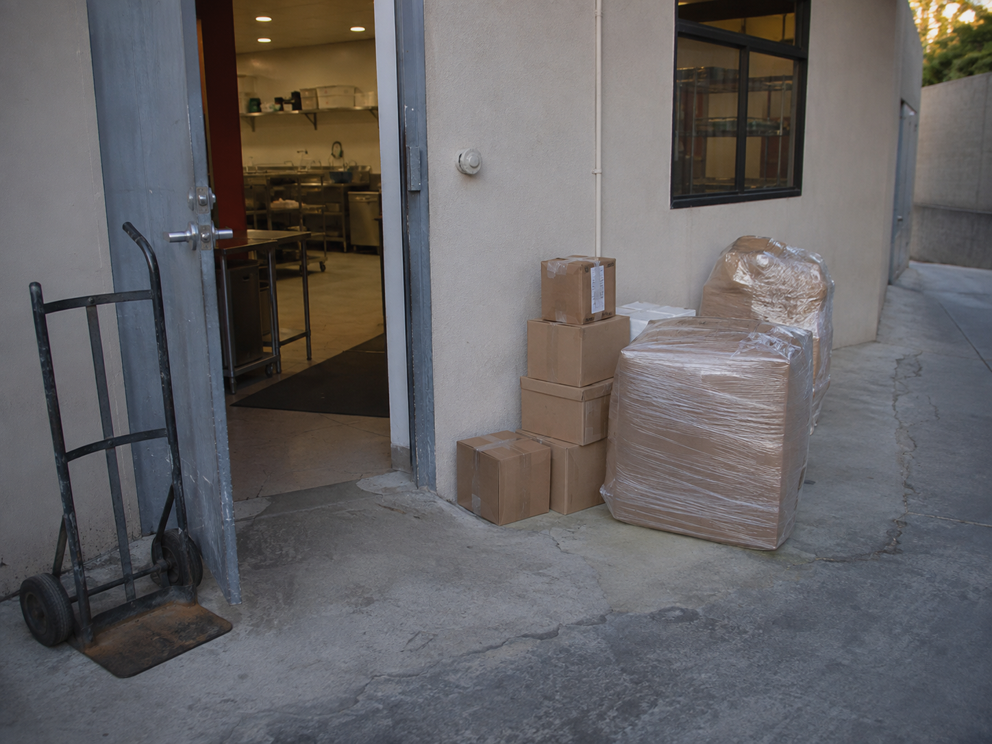 Paquetes y equipo de carga junto a la entrada de una empresa